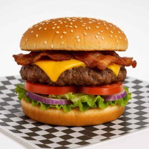 Hyper-realistic 1/3 lb Bacon Cheeseburger on check deli paper with a juicy one-third pound beef patty, topped with melted American cheese, crispy bacon, fresh lettuce, tomato slices, and red onion on a sesame seed bun. Perfect bacon cheeseburger or lunch near me in Newport News.