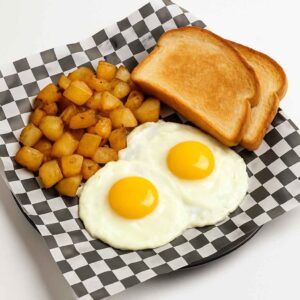 A hyper-realistic image of a 2 Egg Platter featuring two sunny-side-up eggs, golden home fries, and toasted bread slices, served on black-and-white checkered deli paper against a clean white background.