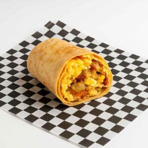 A hyper-realistic image of a breakfast wrap filled with scrambled eggs, cheese, potatoes, and bacon, served on black-and-white checkered deli paper against a clean white background. Perfect choice for anyone searching for Breakfast in Newport News