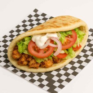 Hyper-realistic Chicken Gyro on check deli paper with grilled seasoned chicken, lettuce, tomato, onions, wrapped in warm pita bread, topped with creamy white sauce. Perfect Halal food or lunch near me in Newport News.