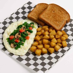 A hyper-realistic image of a Healthy Egg White Platter featuring a fluffy egg white omelet topped with spinach, mushrooms, and diced tomatoes, served with golden home fries and toasted whole wheat bread on black-and-white checkered deli paper. Perfect for anyone searching for breakfast near me in Newport News.
