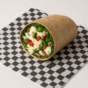 A hyper-realistic image of a Healthy Egg White Wrap made with a whole wheat tortilla, filled with fluffy egg whites, fresh spinach, mushrooms, onions, and red bell peppers, served on black-and-white checkered deli paper against a clean white background. Perfect for anyone searching for Breakfast or Breakfast near me.