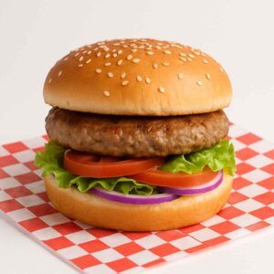 Hyper-realistic Turkey Burger on check deli paper with a savory turkey patty, fresh lettuce, tomato slices, and red onion rings on a sesame seed bun. Perfect turkey burger or lunch near me in Newport News.